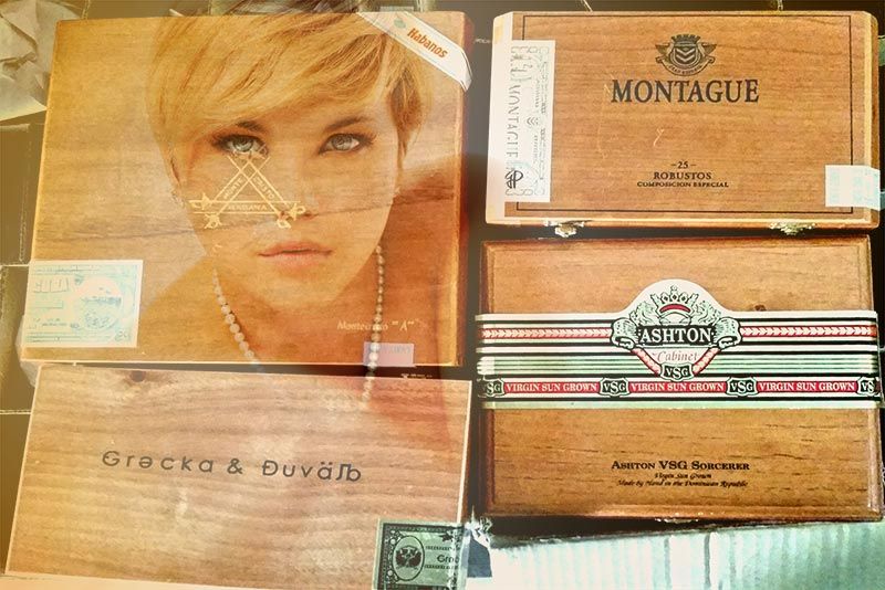 An arrangement of wooden cigar boxes, one lid printed with a woman's portrait, others branded Montague and Ashton
